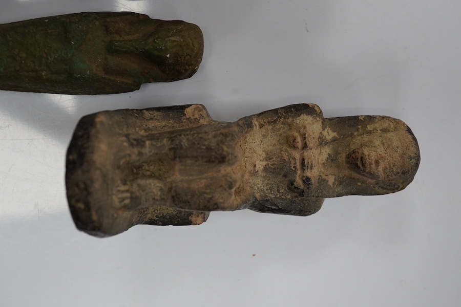 Three ancient Egyptian carved stone ushabti, tallest 15cm, with carved hieroglyphs to the body, together with a seated figure, possibly of Isis, a scarab and a yellow metal brooch with inset stone carved with hieroglyphs